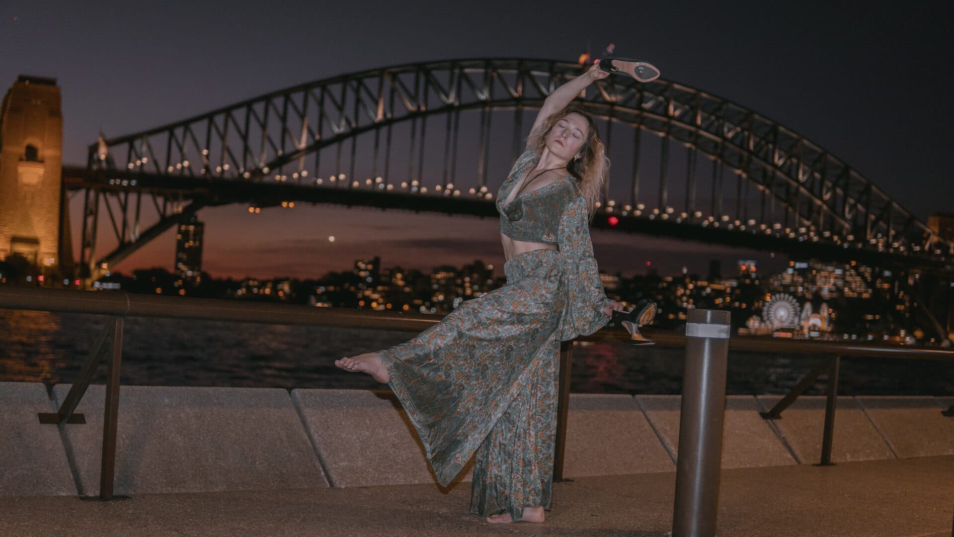 The Bitrates hero: Woman posing with Sydney Harbour Bridge at night